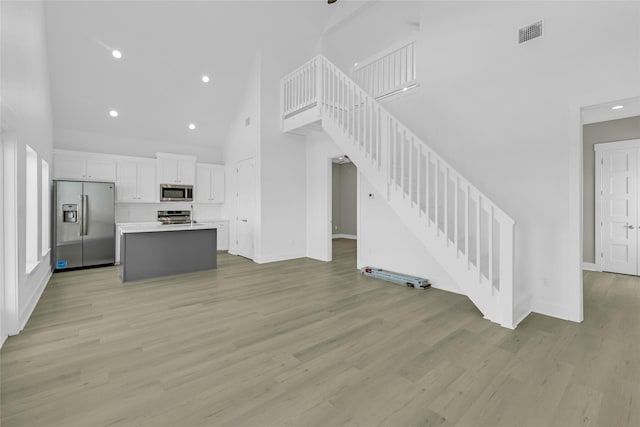 kitchen featuring visible vents, white cabinetry, light countertops, appliances with stainless steel finishes, and a center island