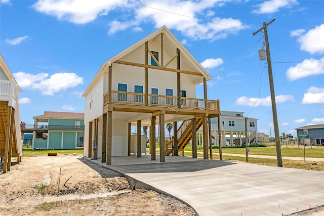 view of front of house with stairway, a porch, a carport, and concrete driveway