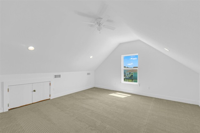 additional living space featuring light colored carpet, lofted ceiling, and ceiling fan