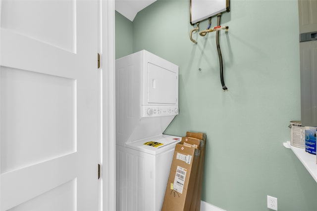 washroom with stacked washer and dryer and water heater