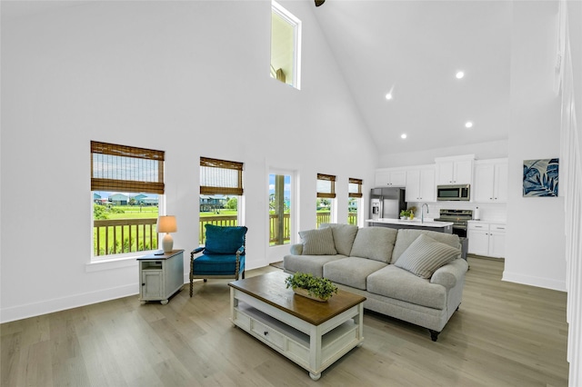 975 Alberdie Dr, Crystal Beach, TX 77650 - living room featuring high vaulted ceiling, plenty of natural light, baseboards, light wood-style flooring, and recessed lighting