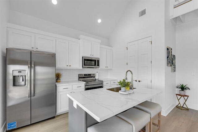 975 Alberdie Dr, Crystal Beach, TX 77650 - kitchen featuring appliances with stainless steel finishes, a sink, light wood-style floors, white cabinetry, and recessed lighting