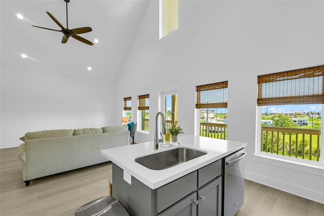 975 Alberdie Dr, Crystal Beach, TX 77650 - kitchen with stainless steel dishwasher, a sink, gray cabinetry, high vaulted ceiling, and light wood-style floors