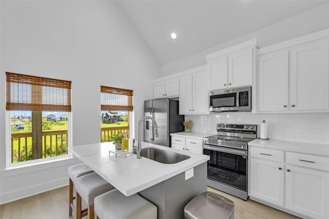 975 Alberdie Dr, Crystal Beach, TX 77650 - kitchen with appliances with stainless steel finishes, a sink, backsplash, high vaulted ceiling, and healthy amount of natural light