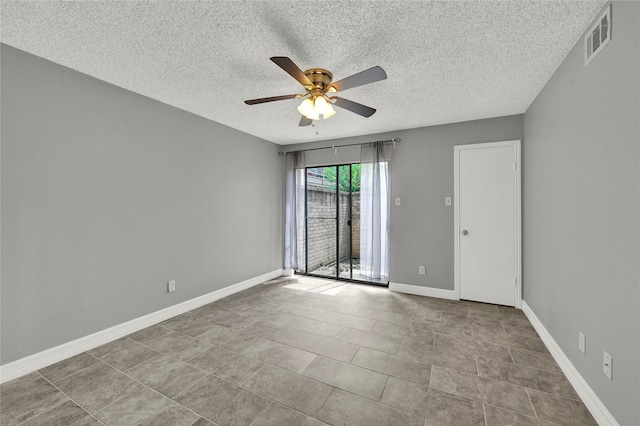 unfurnished room with ceiling fan, a textured ceiling, and tile patterned floors