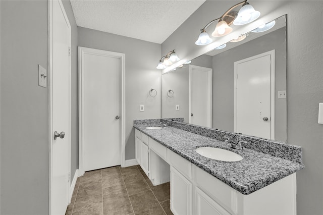 bathroom with tile patterned floors, a textured ceiling, and vanity