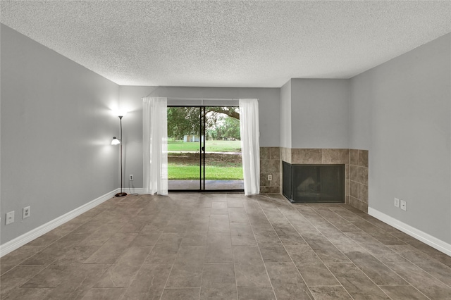 unfurnished living room with a textured ceiling, tile patterned flooring, and a fireplace