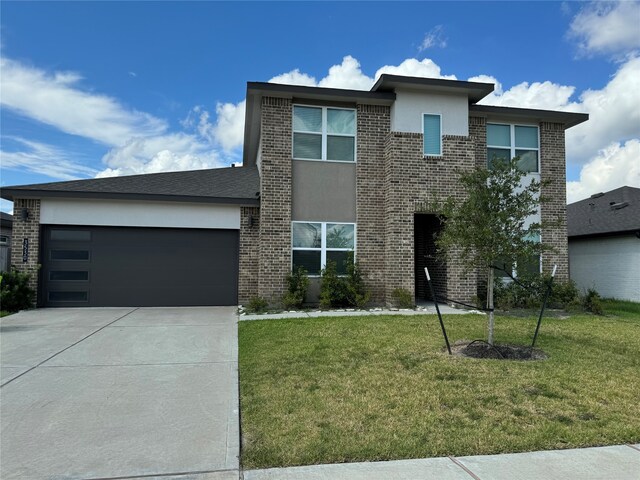 view of front of property featuring a garage and a front lawn