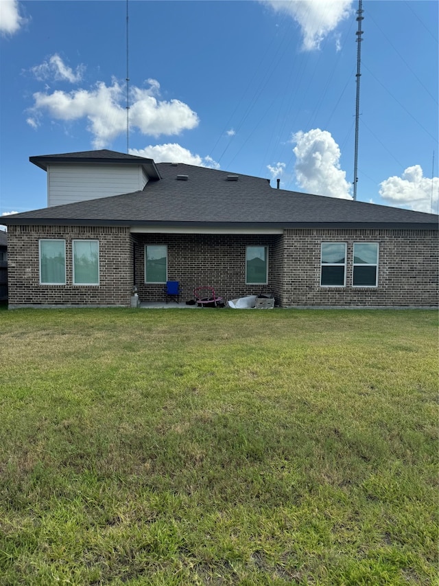 rear view of house featuring a lawn