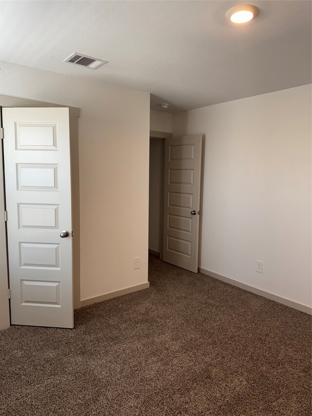 empty room featuring dark colored carpet