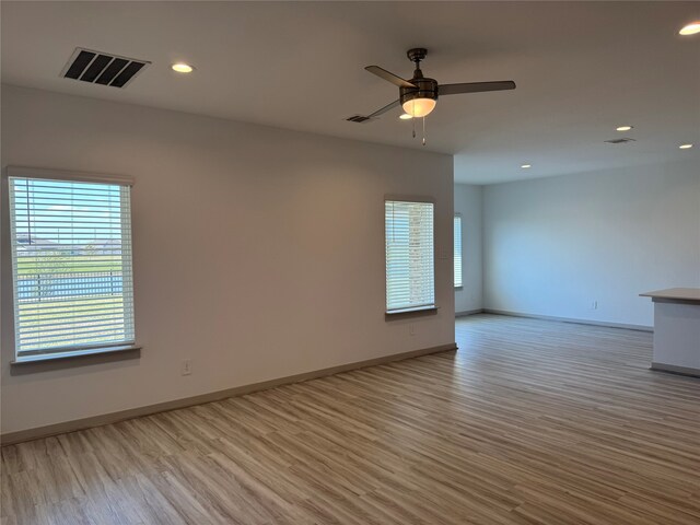 spare room with light wood-type flooring and ceiling fan