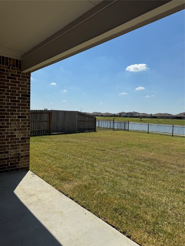 view of yard with a water view and a patio area