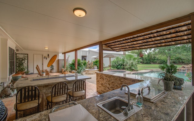 view of patio / terrace featuring an outdoor wet bar and an in ground hot tub