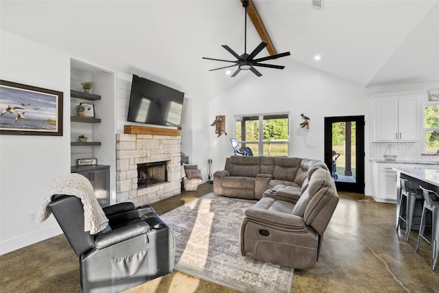 living room with vaulted ceiling with beams, a stone fireplace, and ceiling fan