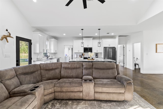 living room featuring ceiling fan, sink, and lofted ceiling