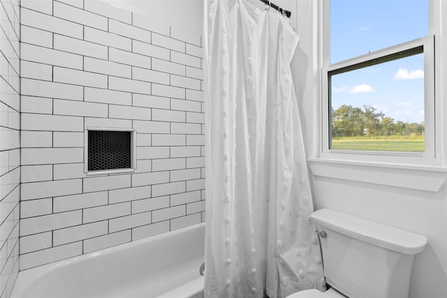 bathroom featuring shower / tub combo, toilet, and plenty of natural light