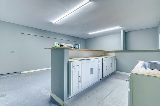 kitchen featuring white cabinetry and sink