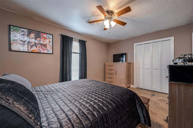 bedroom featuring ceiling fan, a textured ceiling, and a closet