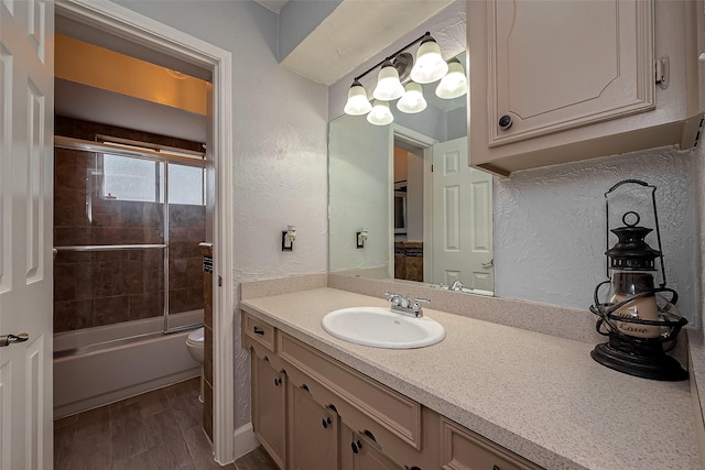 full bathroom with shower / bath combination with glass door, vanity, wood-type flooring, and toilet