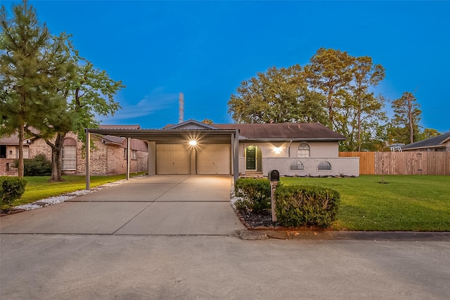 single story home featuring a lawn, a carport, and a garage