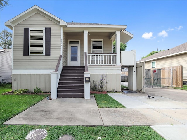 manufactured / mobile home with covered porch, a front lawn, fence, and stairs