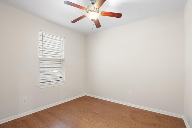 unfurnished room with wood finished floors, a ceiling fan, and baseboards