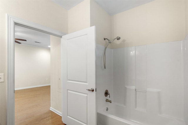 bathroom with  shower combination, baseboards, visible vents, and wood finished floors