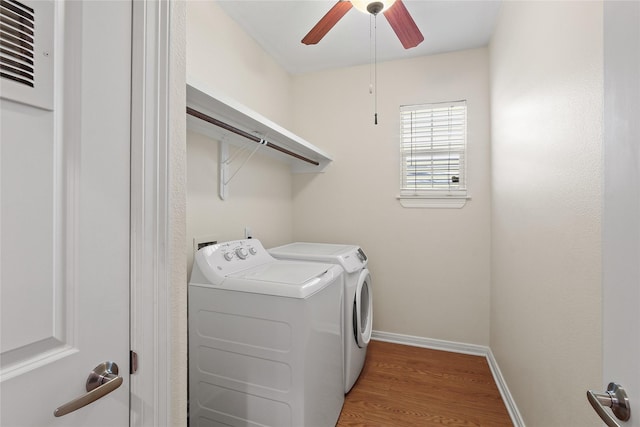 laundry room with washing machine and dryer, laundry area, wood finished floors, a ceiling fan, and baseboards