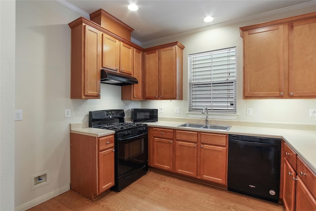 kitchen featuring light countertops, ornamental molding, a sink, under cabinet range hood, and black appliances