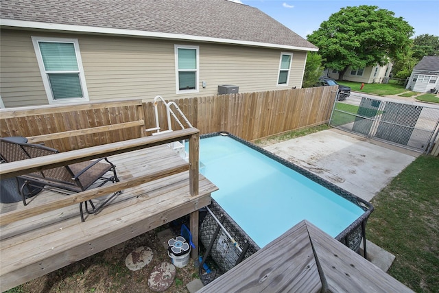 view of swimming pool featuring cooling unit, fence, and a gate