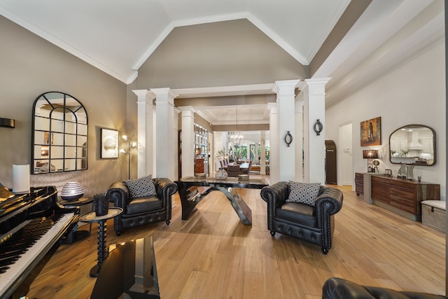 living room with light hardwood / wood-style floors, vaulted ceiling, decorative columns, and crown molding