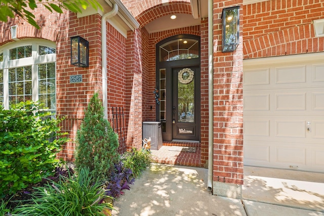 doorway to property with brick siding and an attached garage