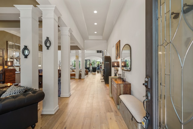 foyer with decorative columns, a high ceiling, and light hardwood / wood-style floors