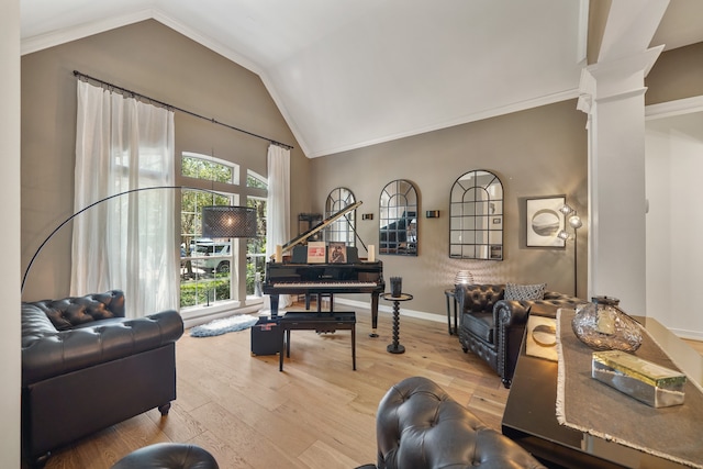 interior space with light hardwood / wood-style floors, decorative columns, vaulted ceiling, and ornamental molding