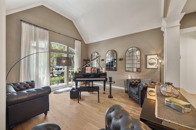 living area with lofted ceiling, wood finished floors, baseboards, ornate columns, and crown molding