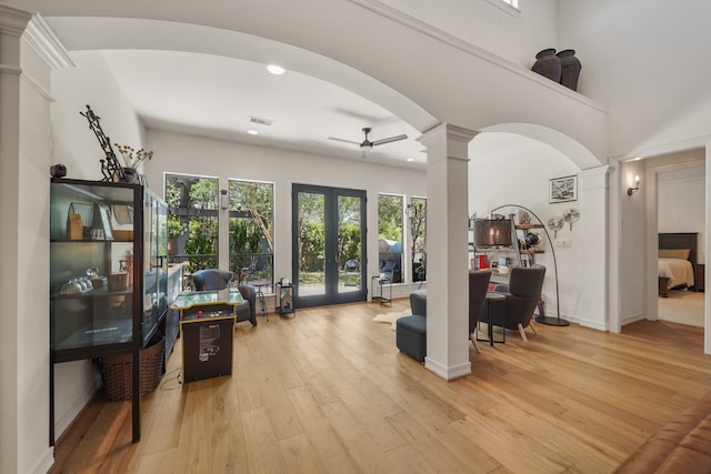 living room featuring ceiling fan, light hardwood / wood-style floors, decorative columns, and french doors