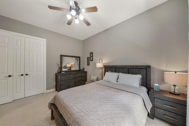 bedroom featuring light carpet, ceiling fan, baseboards, and a closet