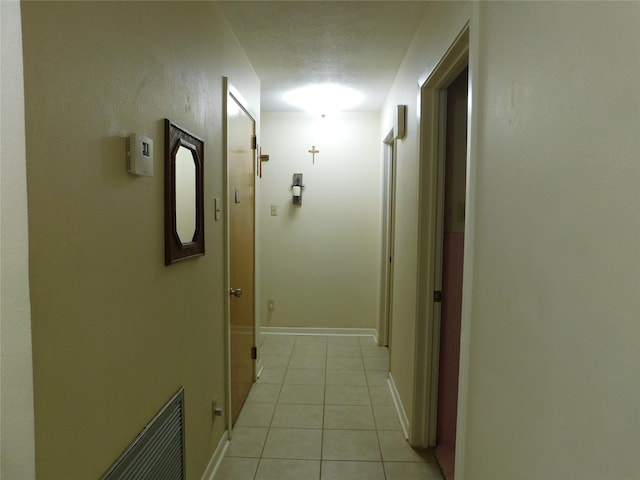 corridor with light tile patterned floors and baseboards