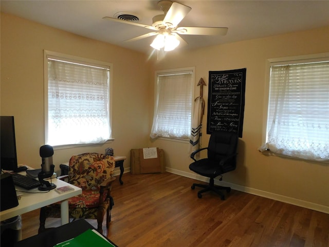 home office featuring a ceiling fan, visible vents, baseboards, and wood finished floors