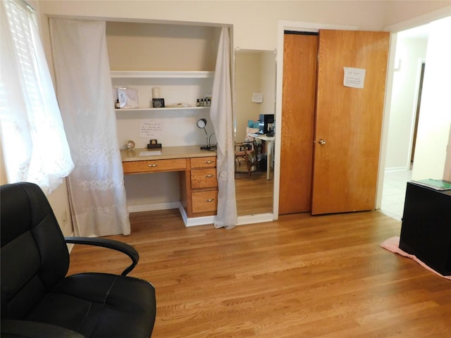 interior space with light wood-type flooring and built in desk