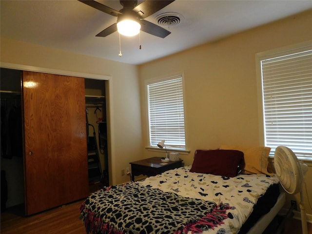 bedroom with a closet, visible vents, ceiling fan, and wood finished floors