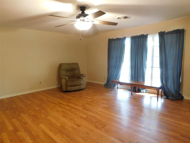 unfurnished room with baseboards, ceiling fan, visible vents, and light wood-style floors