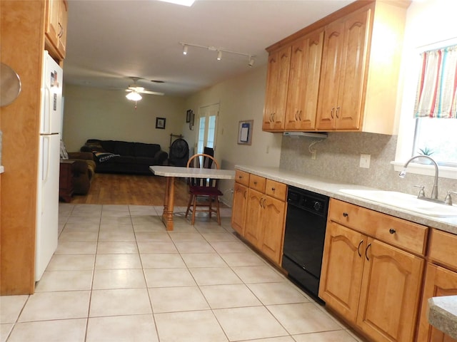 kitchen with light tile patterned floors, decorative backsplash, dishwasher, light countertops, and a sink