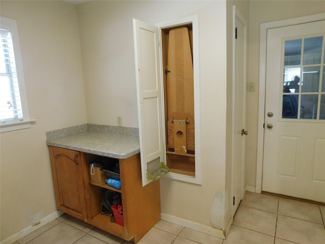 interior space featuring baseboards and light tile patterned floors