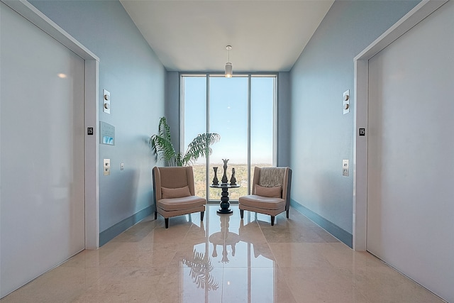 sitting room with light tile patterned floors, elevator, and floor to ceiling windows