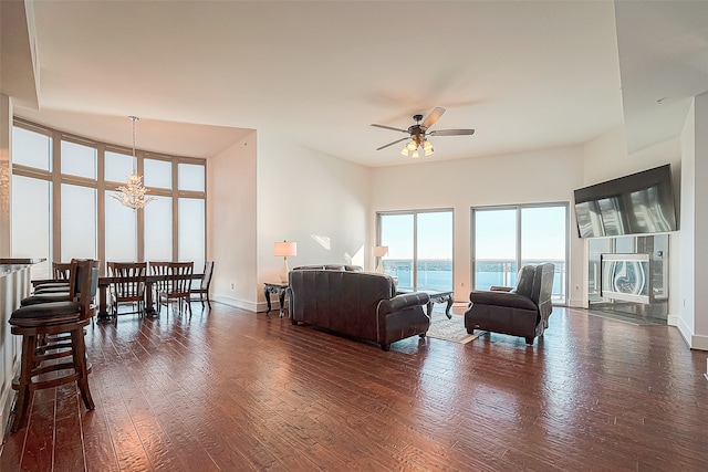 living room featuring ceiling fan and dark hardwood / wood-style flooring