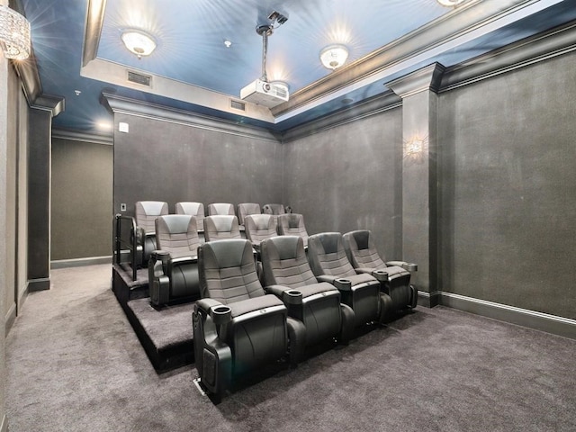 carpeted home theater room featuring crown molding and a tray ceiling