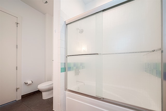 bathroom featuring combined bath / shower with glass door, toilet, and tile patterned flooring