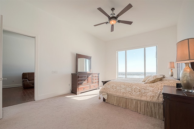 carpeted bedroom with ceiling fan, access to outside, and a water view