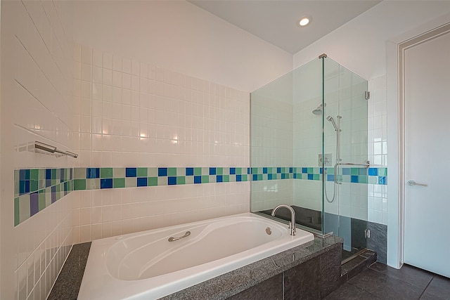 bathroom with tile patterned floors, shower with separate bathtub, and tile walls